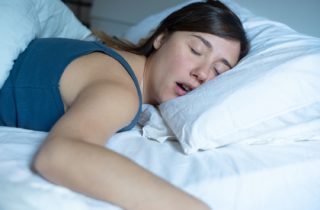 Woman sleeping on her stomach possibly snoring sleep health dentist in Poquoson Virginia